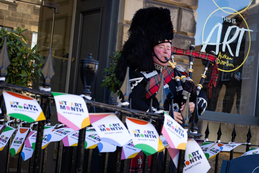 Bagpiper in traditional Scottish dress plays at New Town Art Month event