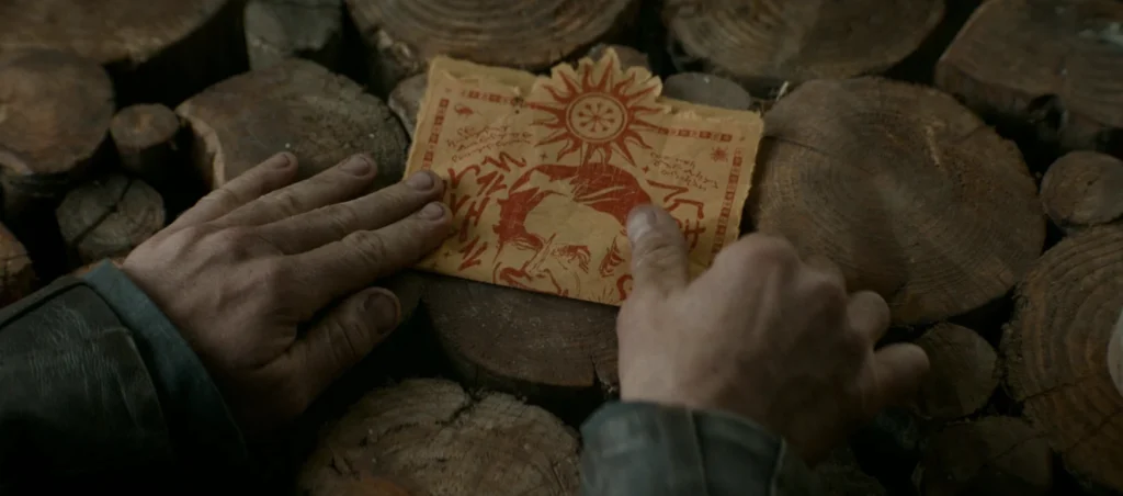Dungeons and Dragons: Hands examine a D&D map with a portrait and sun symbol.