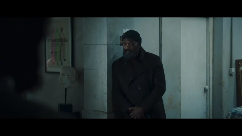 Nick Fury in Secret Invasion hides behind a wall, holding a gun.