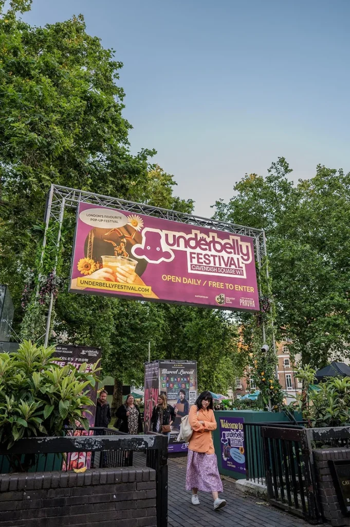 Underbelly Festival Cavendish Square banner hanging above people and trees
