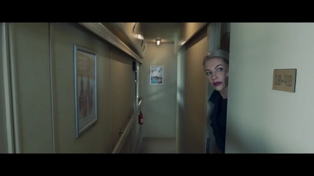 Woman peeks around a door in a train car hallway, apartment 18-48 visible.