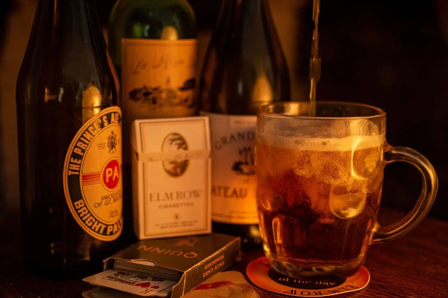 Beer mug, playing cards, and bottles of Prince Albert, Elm Row, and Quinn