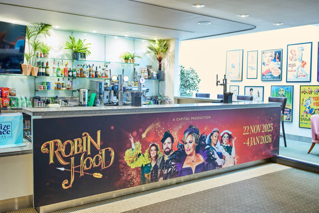 Robin Hood theatre production banner on a bar, featuring cast and show dates.
