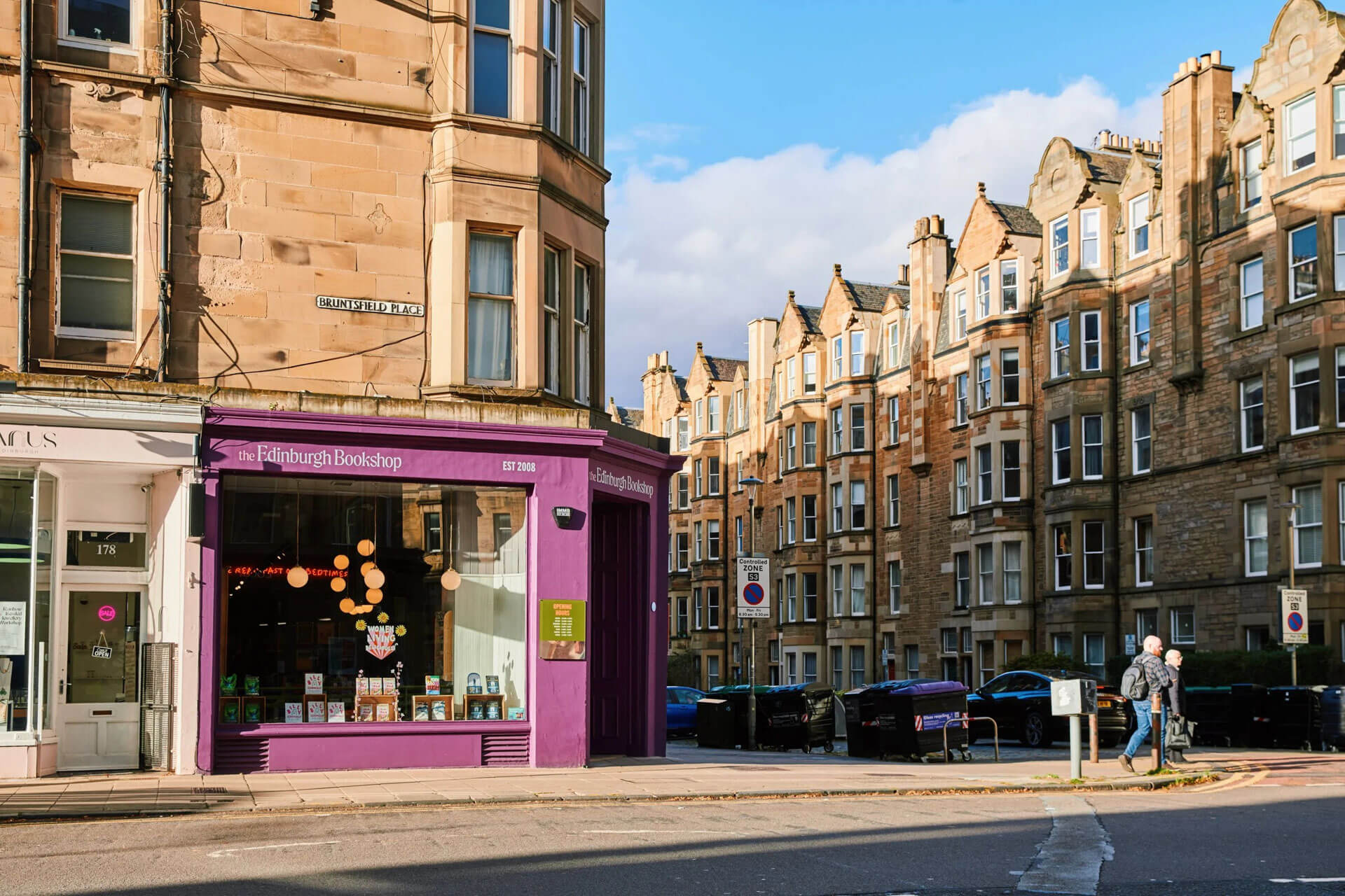 The Edinburgh Bookshop on a sunny street corner with traditional buildings