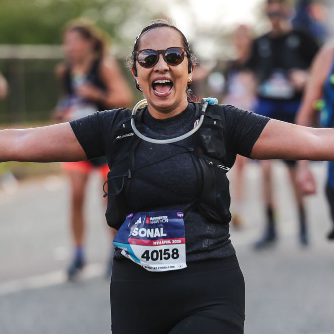 Woman with bib number 40158 running a marathon, smiling.